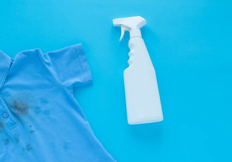 dirty black spots on clothes and stain remover. Stain cleaners. Isolated on a blue background. High quality photo